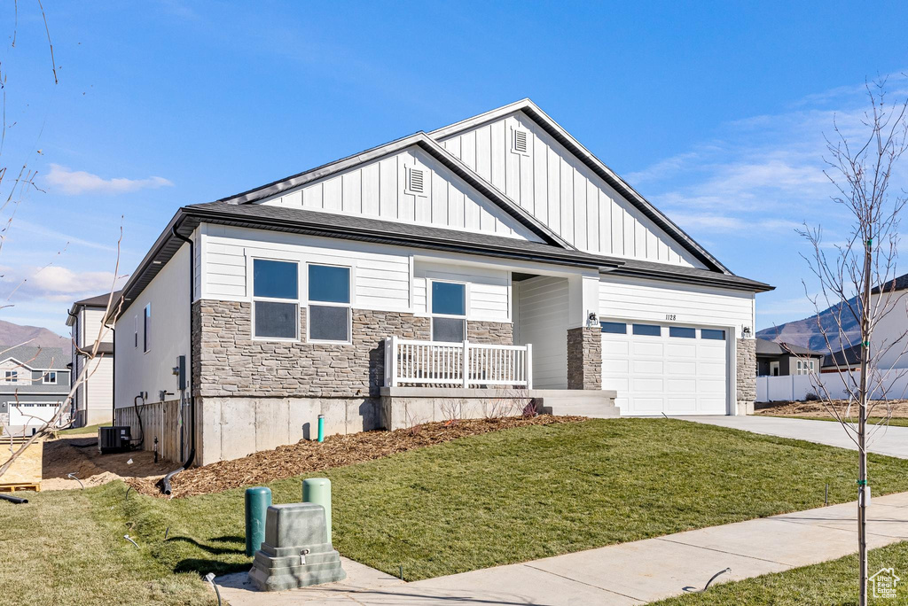 Craftsman-style home featuring a garage and a front lawn