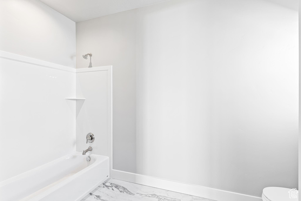 Bathroom with tile floors, toilet, and bathing tub / shower combination