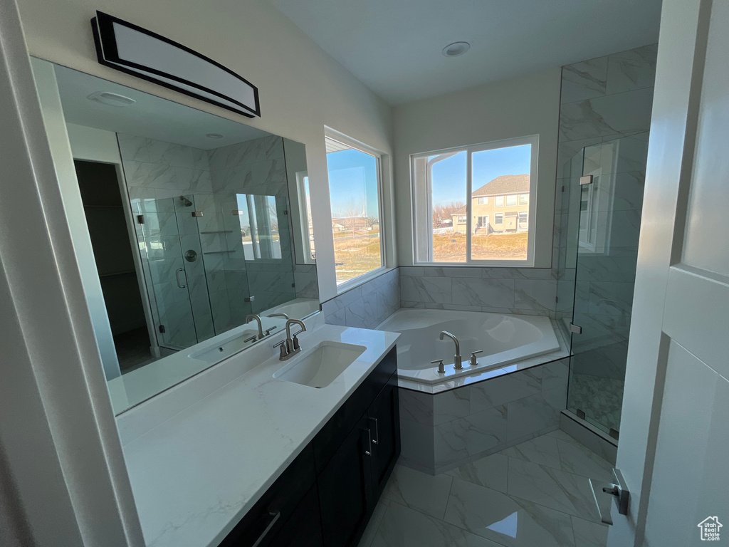 Bathroom with tile floors, vanity with extensive cabinet space, and plus walk in shower