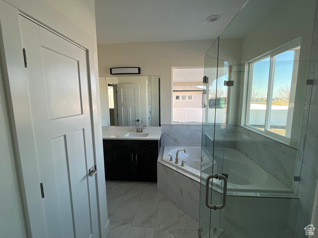 Bathroom featuring tile floors, vanity, a wealth of natural light, and independent shower and bath