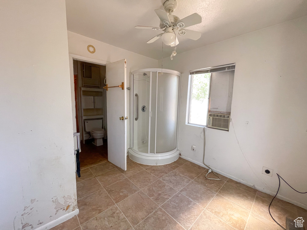 Unfurnished bedroom featuring ensuite bath, tile flooring, and ceiling fan