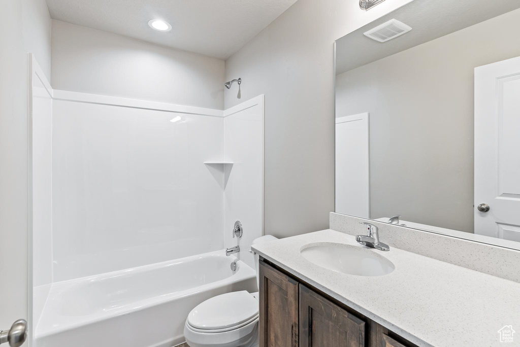 Full bathroom with toilet, vanity, and washtub / shower combination