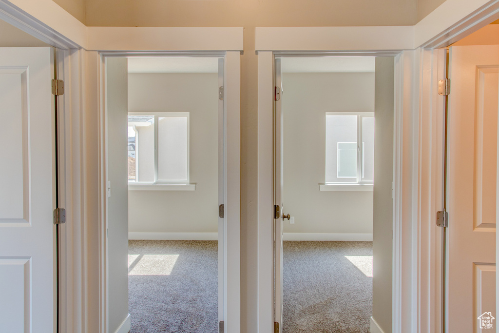 Corridor featuring light carpet