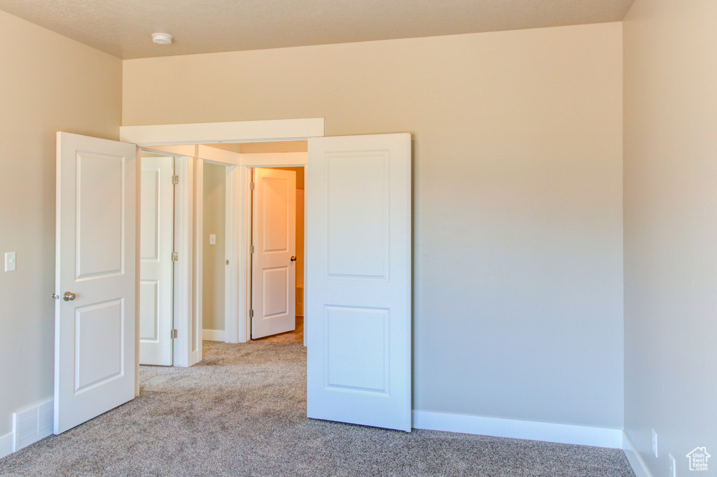 Unfurnished room with light colored carpet