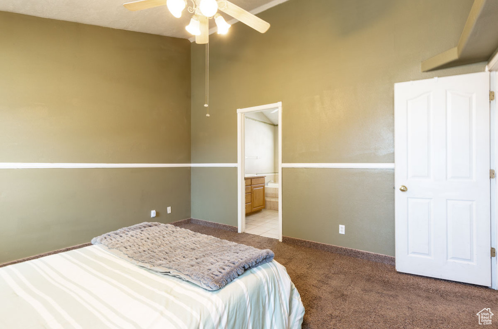 Bedroom featuring ensuite bathroom, carpet floors, and ceiling fan