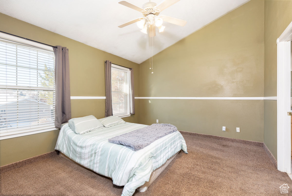 Bedroom featuring vaulted ceiling, light carpet, and ceiling fan