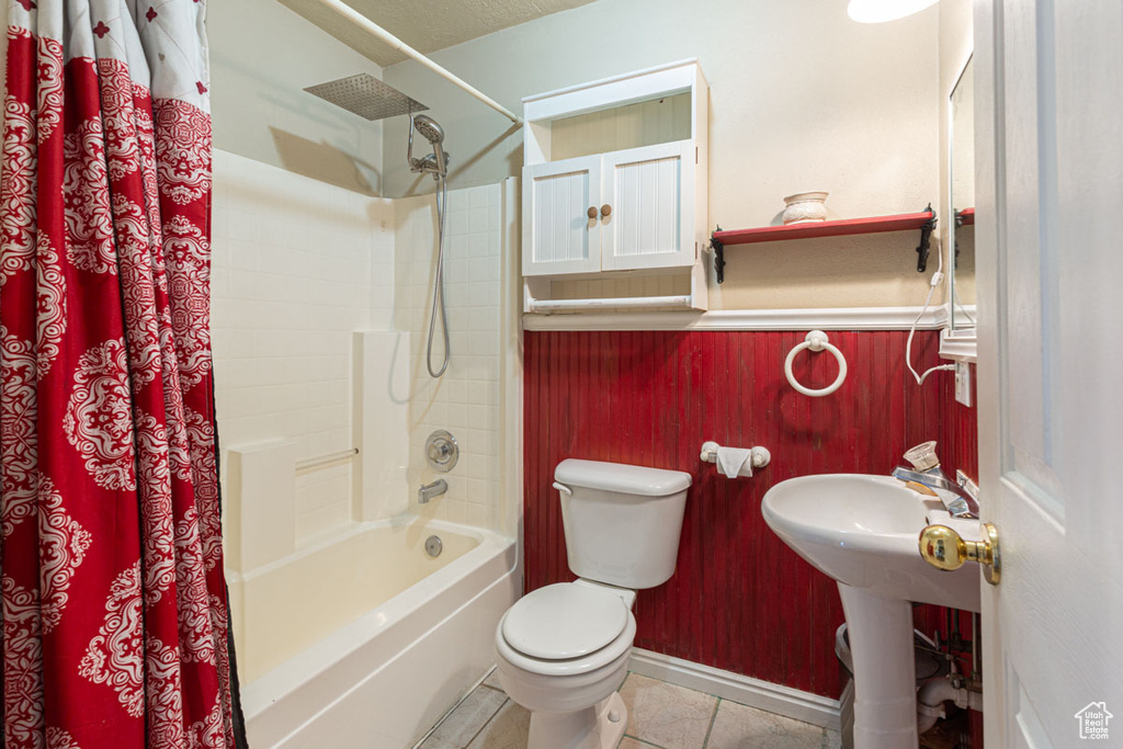 Full bathroom with shower / bath combo, toilet, tile flooring, and sink