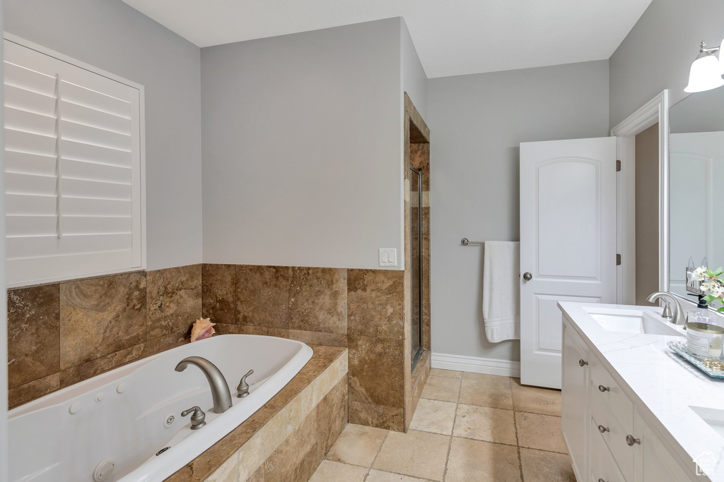 Bathroom with tile floors, separate shower and tub, and dual bowl vanity