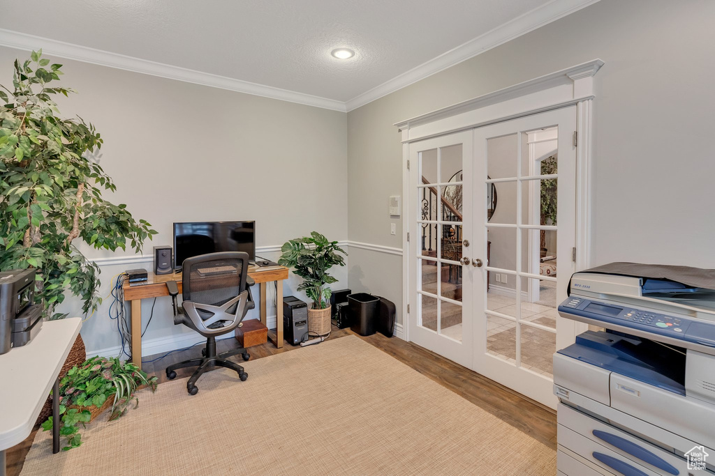 Home office with ornamental molding, light wood-type flooring, and french doors