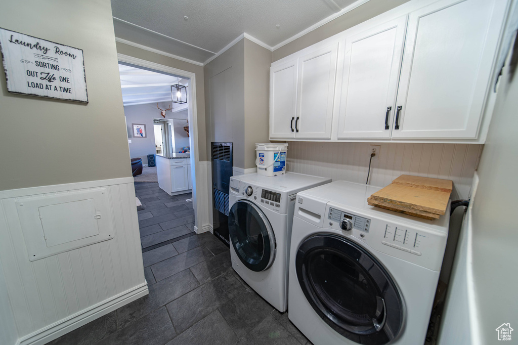 Laundry room featuring ornamental molding, independent washer and dryer, cabinets, and dark tile flooring