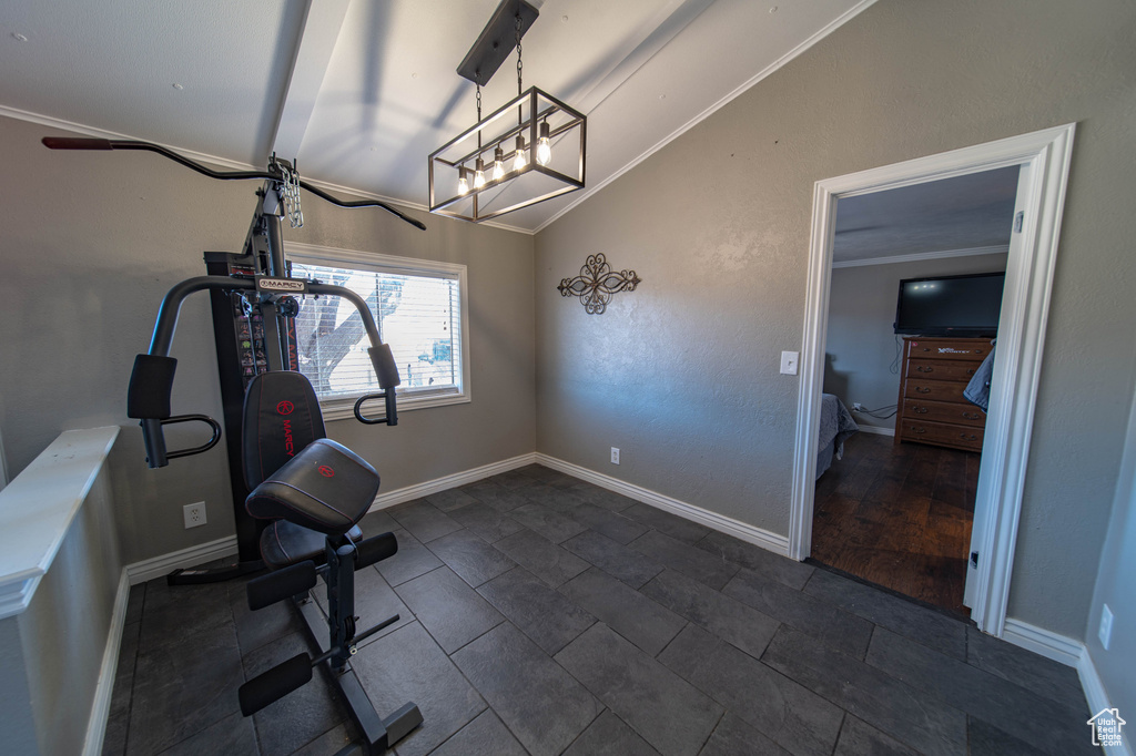 Exercise room featuring crown molding, dark tile flooring, and vaulted ceiling