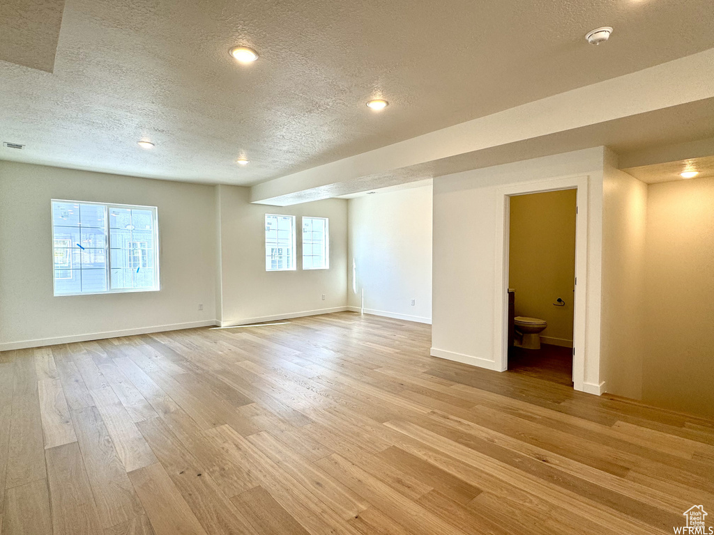 Unfurnished room featuring a textured ceiling and light hardwood / wood-style flooring