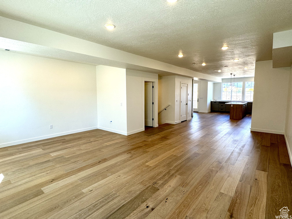 Unfurnished living room with a textured ceiling and hardwood / wood-style flooring