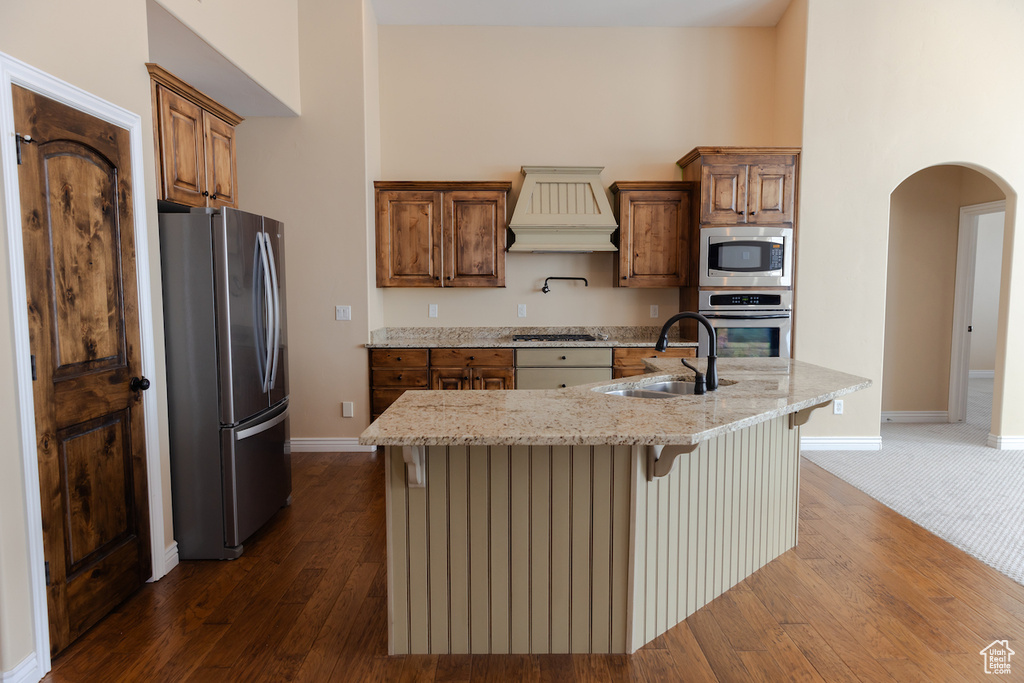 Kitchen with dark wood-type flooring, sink, custom exhaust hood, and stainless steel appliances