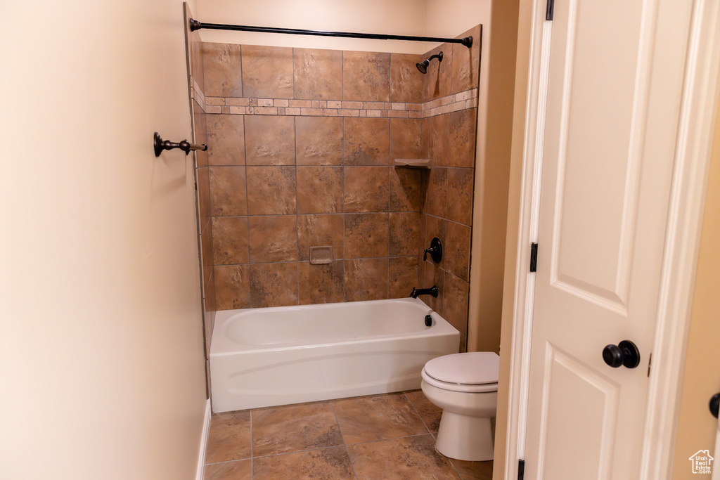 Bathroom featuring tile floors, tiled shower / bath combo, and toilet