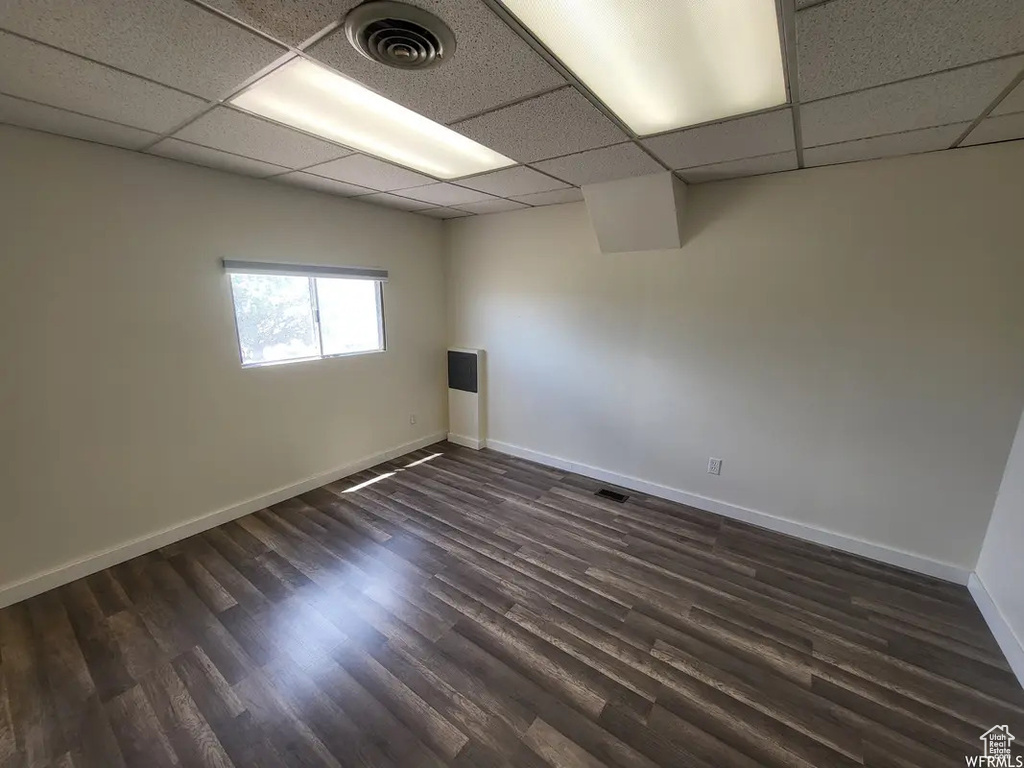 Unfurnished room with dark wood-type flooring and a paneled ceiling