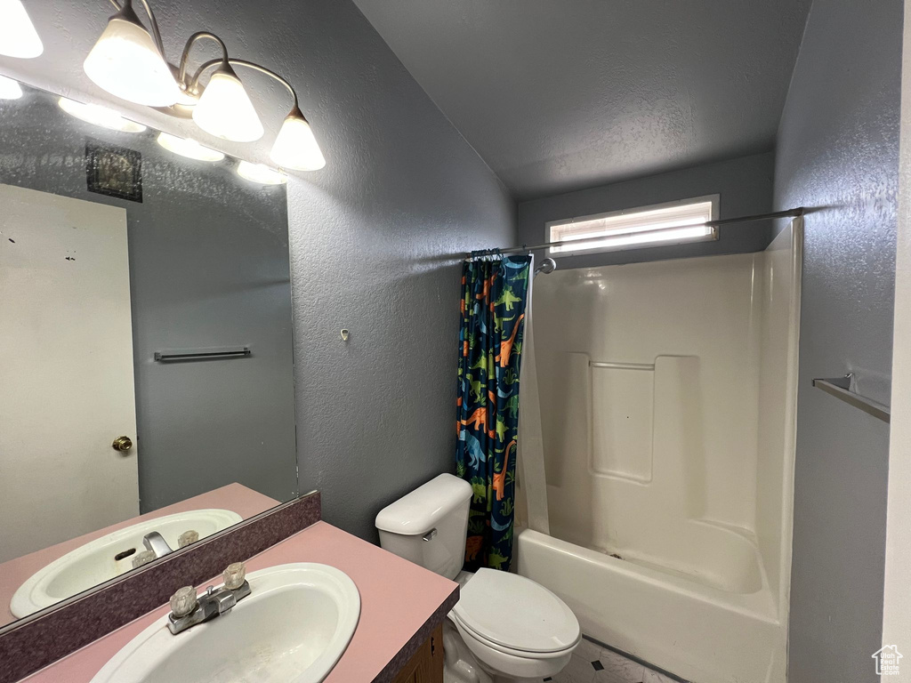 Full bathroom featuring toilet, vanity, and shower / bath combo