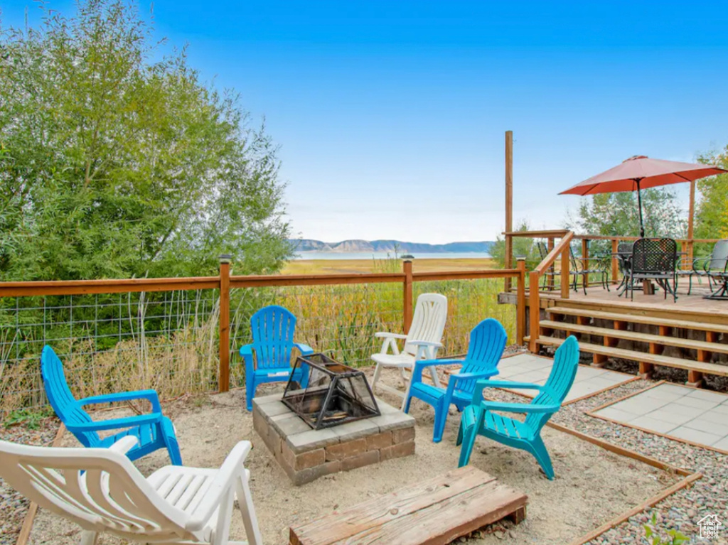 View of patio / terrace featuring a wooden deck and an outdoor fire pit