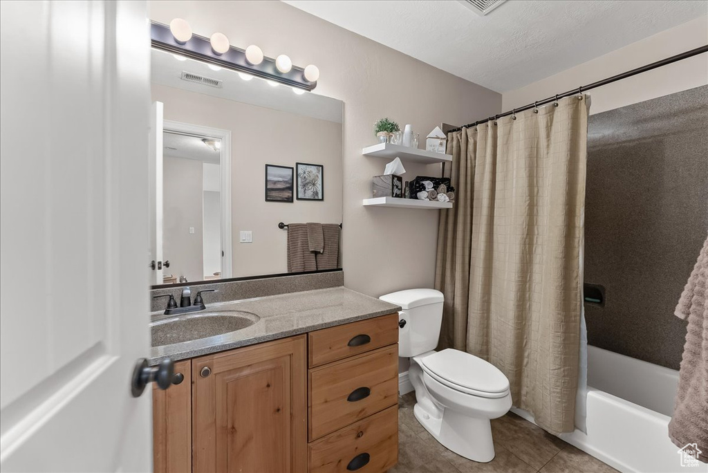 Full bathroom with shower / tub combo, toilet, vanity, and tile floors