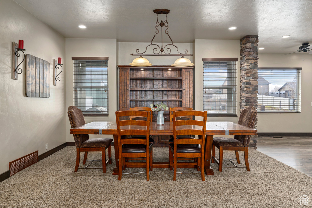 Dining space featuring a textured ceiling, hardwood / wood-style floors, and ceiling fan