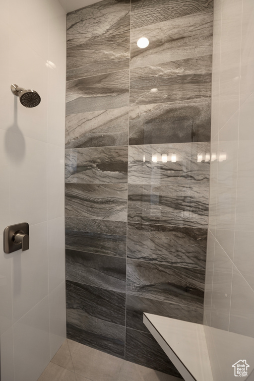 Full bath featuring tiled shower and tile patterned flooring