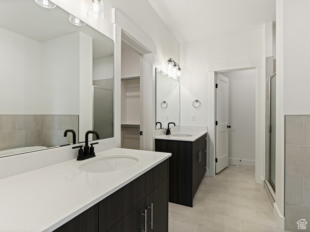 Bathroom featuring tile floors, dual vanity, and plus walk in shower