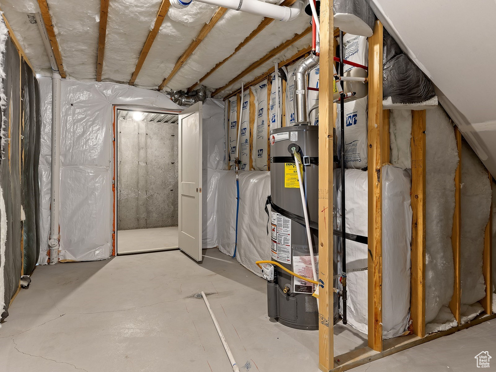 Basement featuring strapped water heater