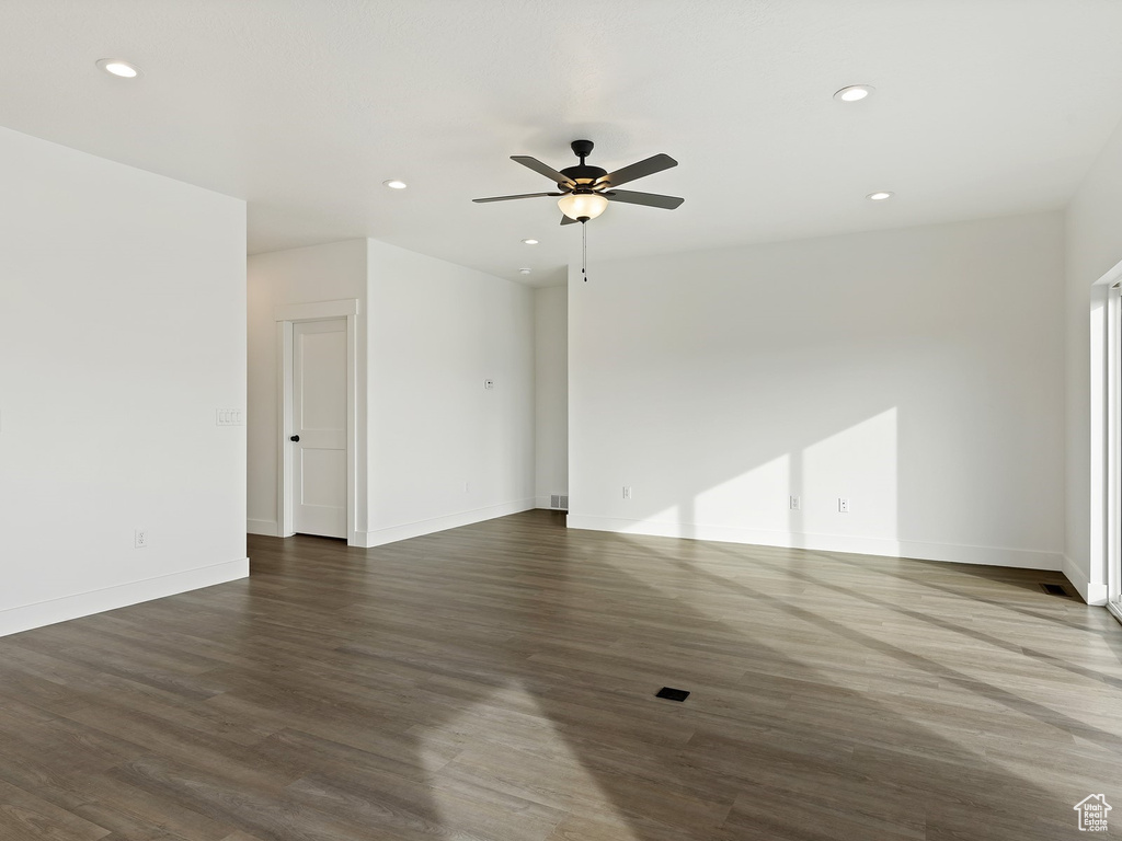 Empty room with dark hardwood / wood-style floors and ceiling fan