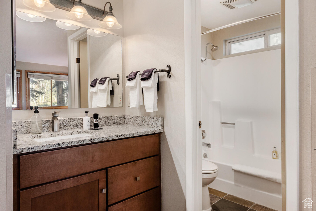 Full bathroom featuring tile floors, toilet, bathtub / shower combination, and oversized vanity