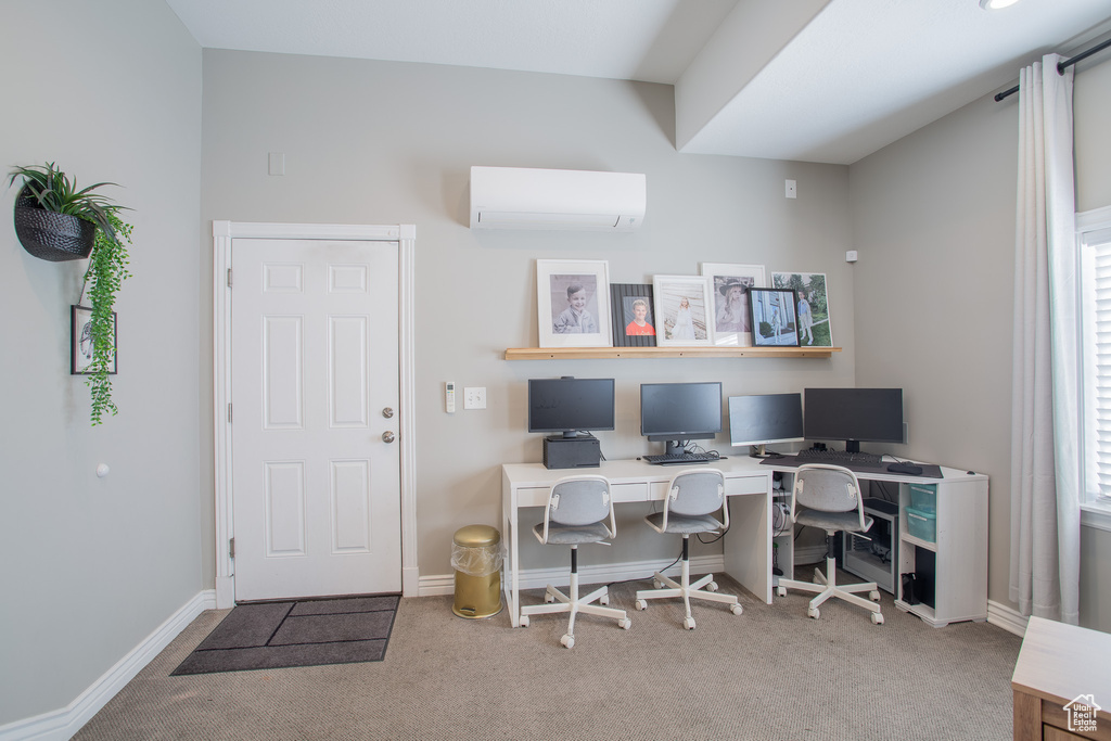 Office area with a wall mounted air conditioner and light colored carpet