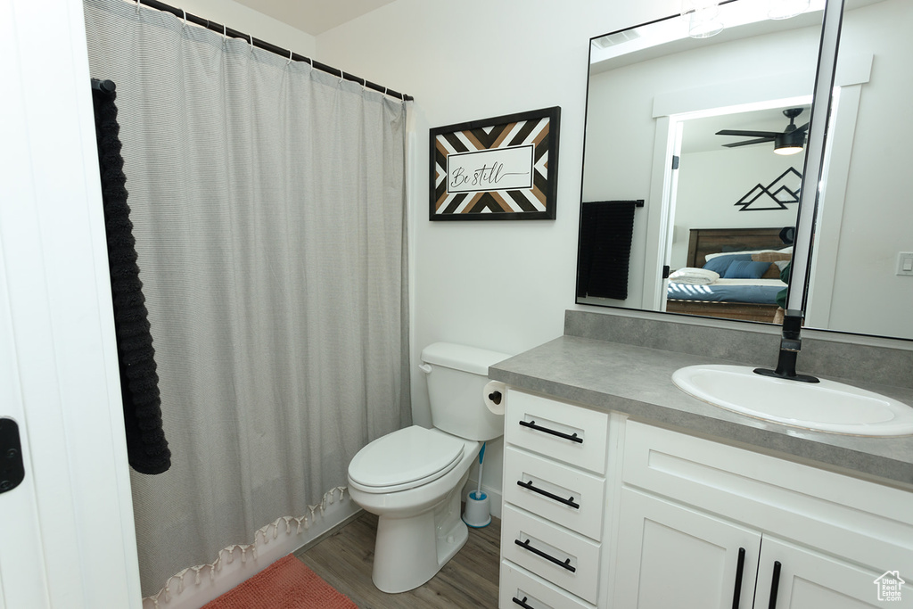 Bathroom featuring hardwood / wood-style floors, large vanity, toilet, and ceiling fan