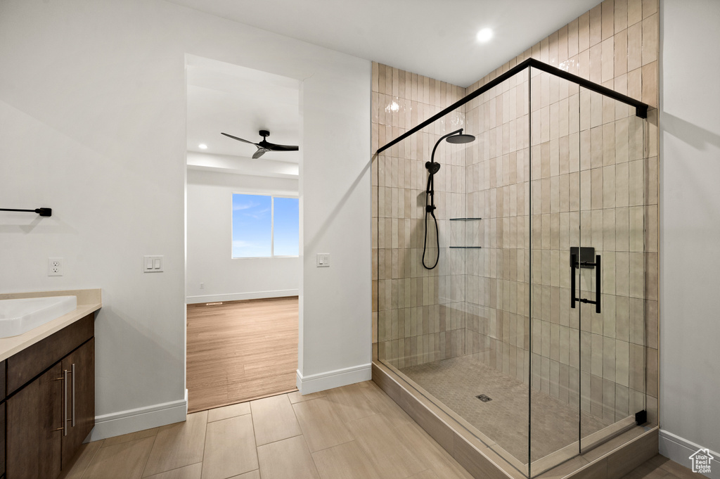 Bathroom featuring tile floors, ceiling fan, vanity, and walk in shower
