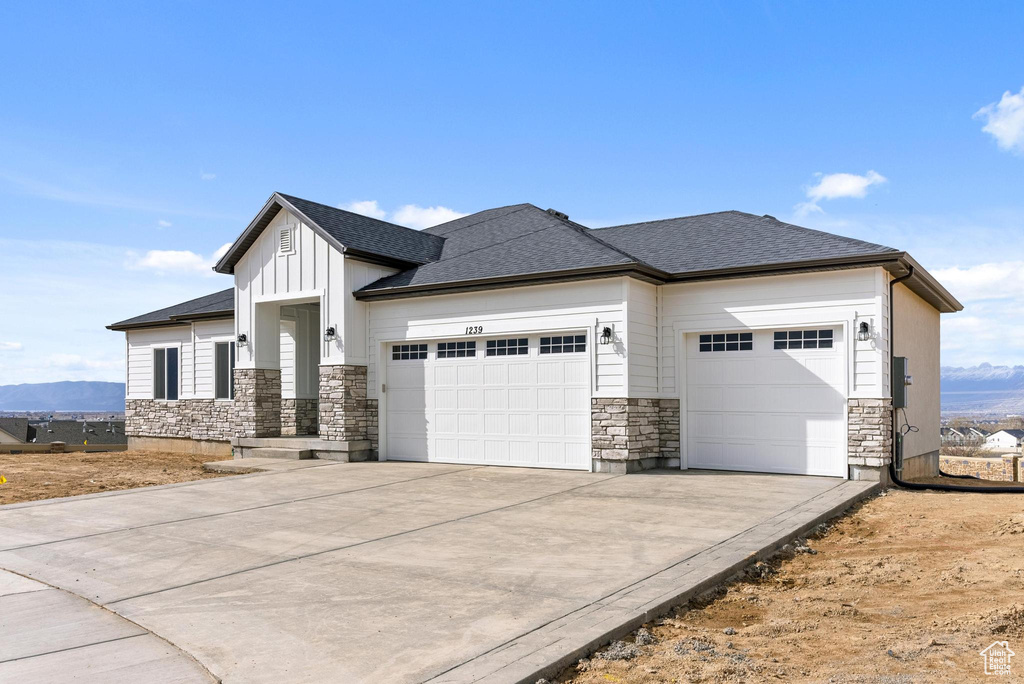 View of front of property with a garage and a mountain view