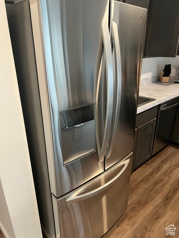 Room details with wood-type flooring, dishwasher, and stainless steel fridge with ice dispenser