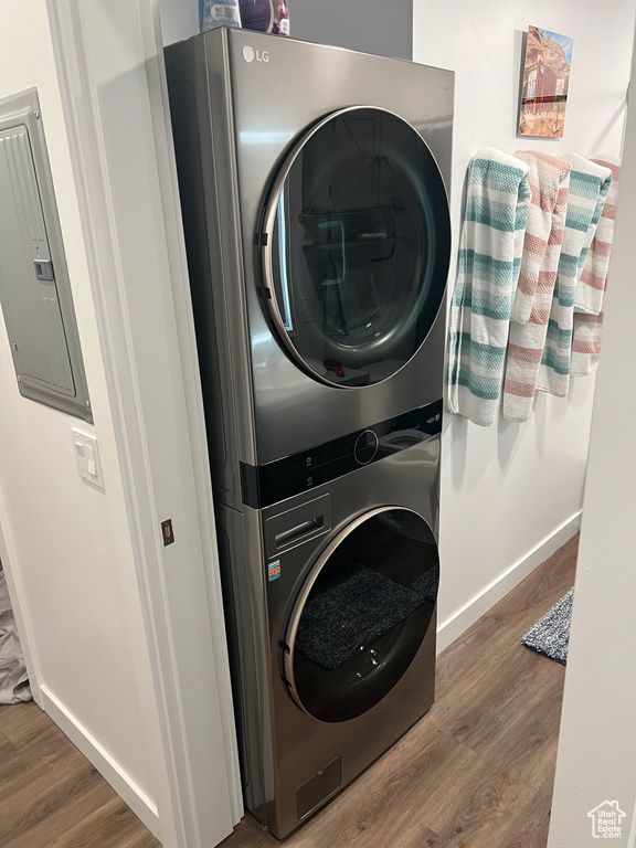 Clothes washing area featuring dark hardwood / wood-style floors and stacked washer and dryer
