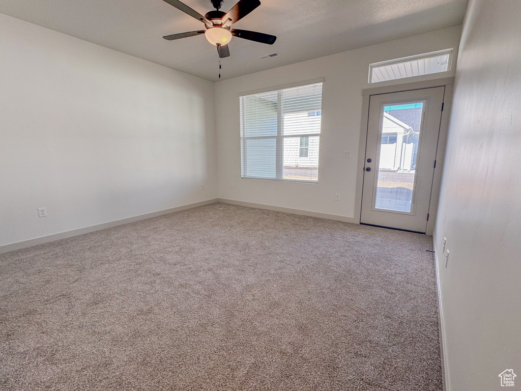 Unfurnished room featuring light carpet and ceiling fan