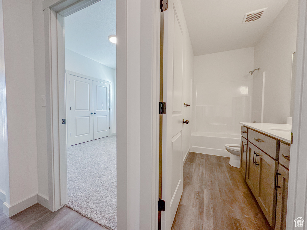 Full bathroom featuring toilet, shower / bath combination, vanity, and hardwood / wood-style flooring
