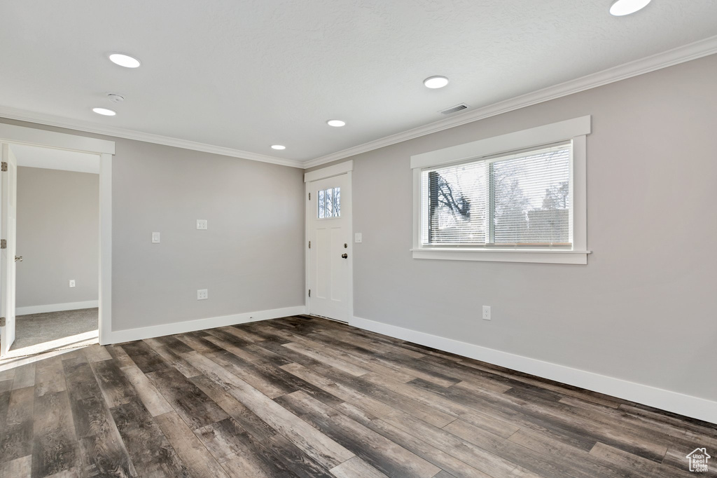 Unfurnished room featuring crown molding and dark hardwood / wood-style flooring