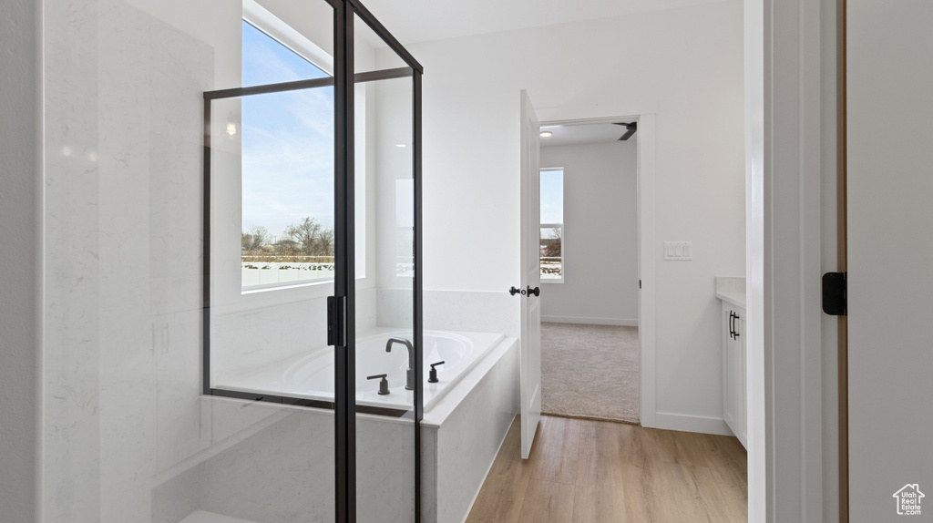 Bathroom featuring hardwood / wood-style floors, independent shower and bath, and vanity