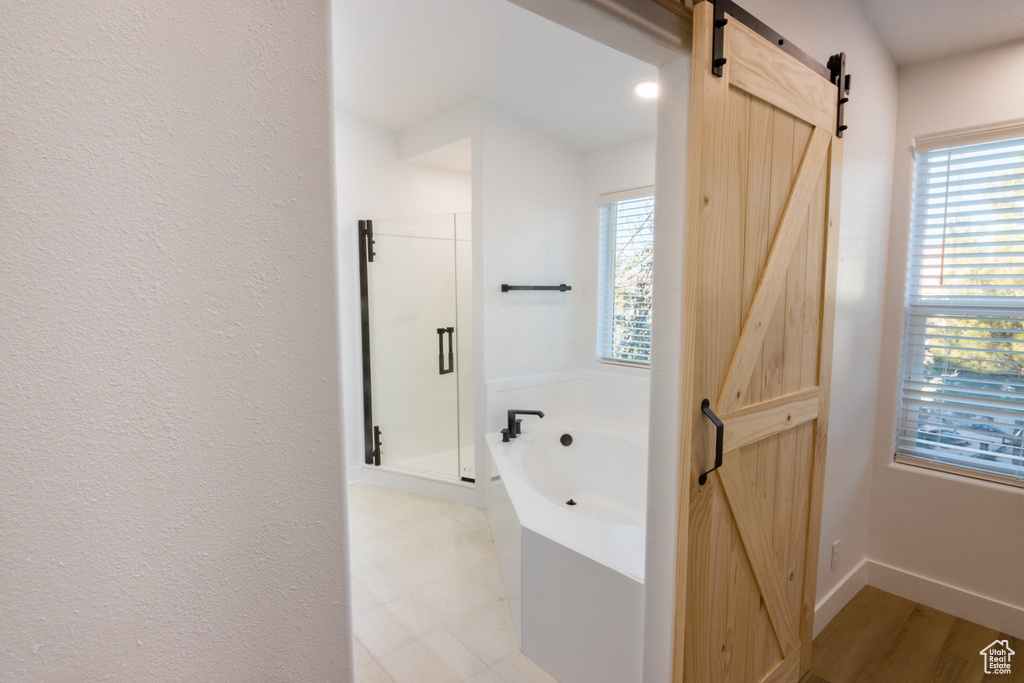 Bathroom featuring a healthy amount of sunlight, plus walk in shower, and tile flooring