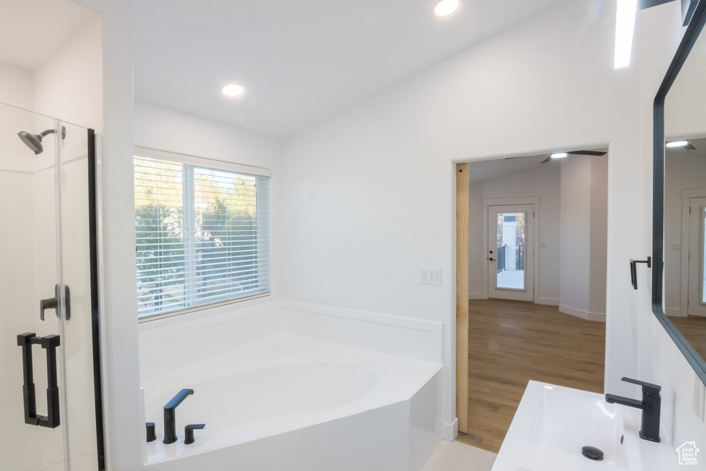 Bathroom featuring sink, vaulted ceiling, separate shower and tub, and hardwood / wood-style floors