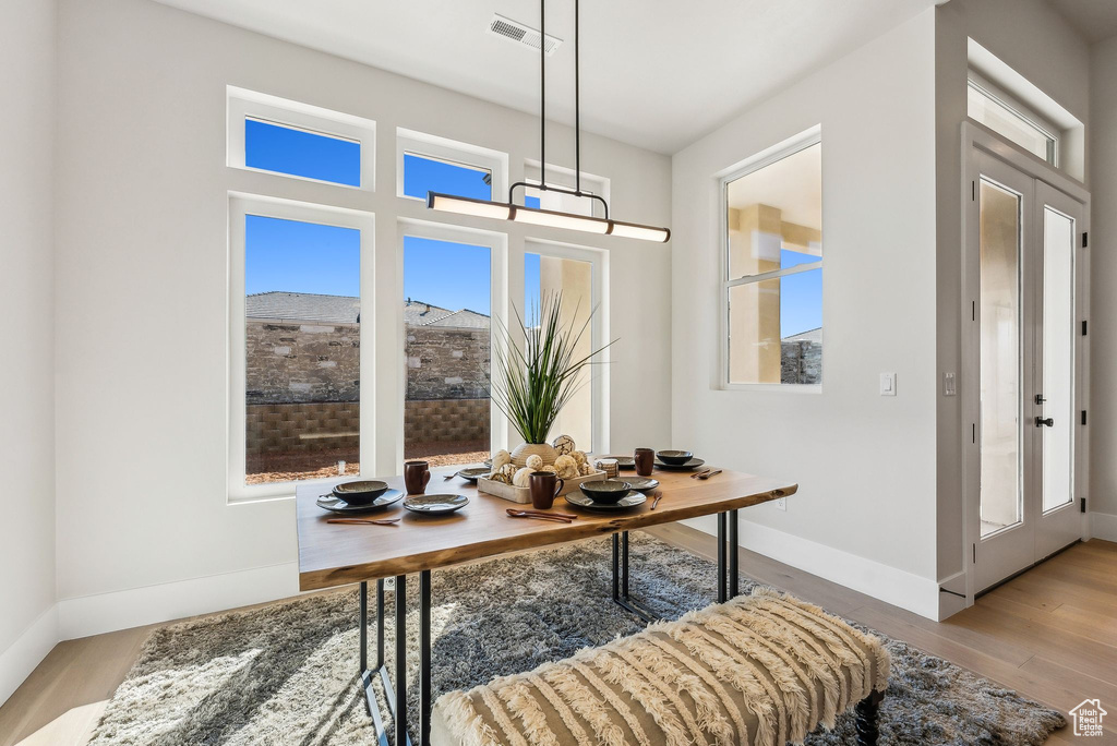 Home office featuring a healthy amount of sunlight, baseboards, wood finished floors, and visible vents