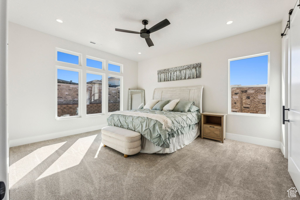 Carpeted bedroom featuring visible vents, baseboards, recessed lighting, a barn door, and a ceiling fan