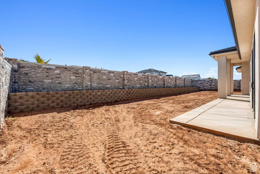 View of yard featuring a fenced backyard and a patio