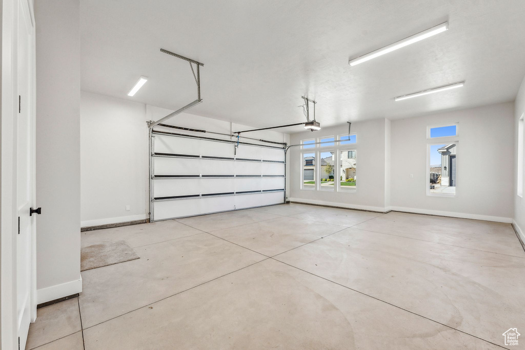 Garage with baseboards and a garage door opener