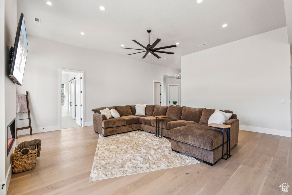 Living room featuring baseboards, recessed lighting, ceiling fan, and light wood-style flooring