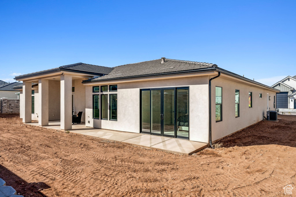 Back of house featuring a patio area, stucco siding, and a tiled roof