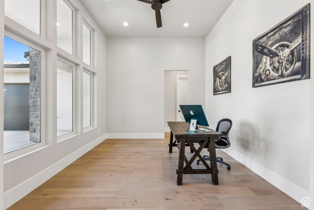 Home office featuring a ceiling fan, a healthy amount of sunlight, and light wood-style floors