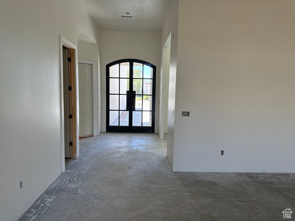 Hall with concrete flooring and french doors