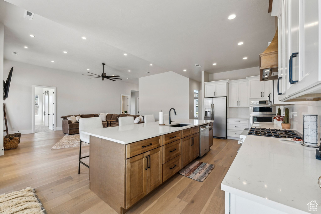 Kitchen with a sink, stainless steel appliances, open floor plan, a large island, and visible vents